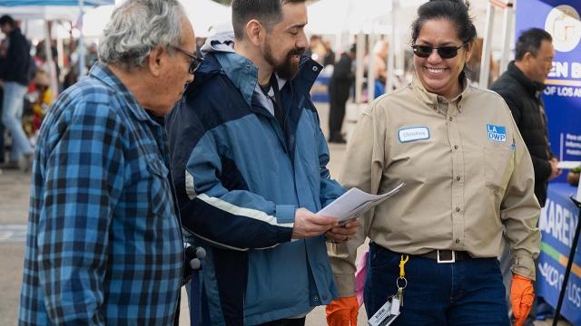 3 people walking at a community fair