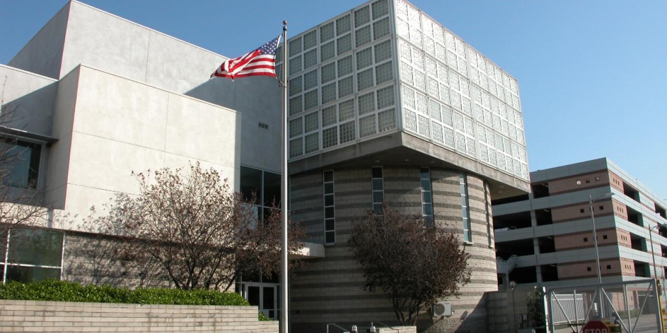 Central District Administration Building Entrance and Flag Pole, Parking Structure in background.