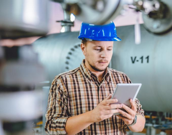 A worker in a hard hat uses an energy calculator.