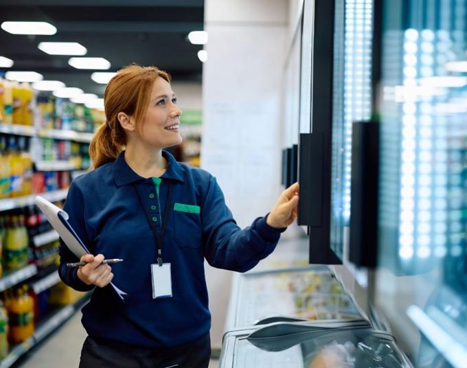 woman looking in refrigeration section of store