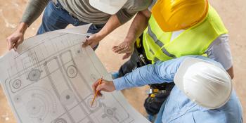 three workers looking at blueprint - Zero by Design program banner