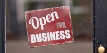 A sign on a shop door reads: Open for Business