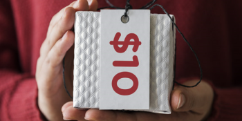 Person holding a white box with the words $10 shown on a gift tag.