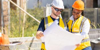 Man and Women review drafting plans at construction site