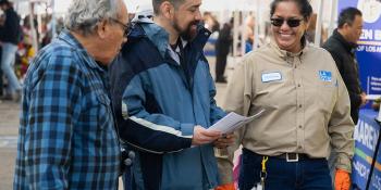 3 people walking at a community fair