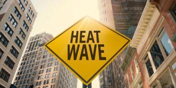 heat wave sign in front of tall buildings